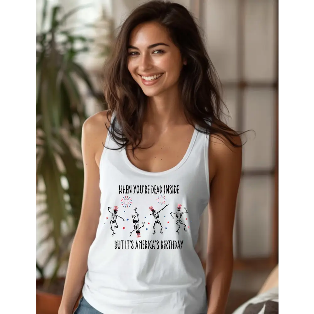 Model wearing a white racerback tank top with a design of dancing skeletons with fireworks.